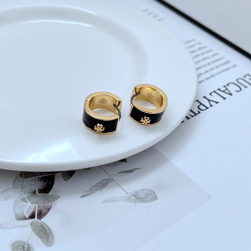 : A stylish, confident woman with a contemporary look, wearing the hoops. She might be in a minimalist urban setting, smiling, with her hair up or back to fully display the bold earrings.