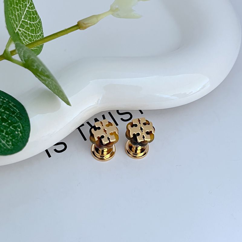 Earrings arranged with other minimalist, tone-neutral accessories to emphasize their adaptability.
