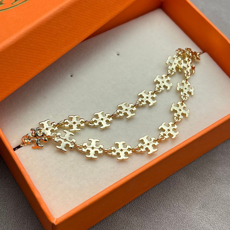 Close-up of the chevron pendant, highlighting the gold plating finish, any engraved lines, and precise edges.