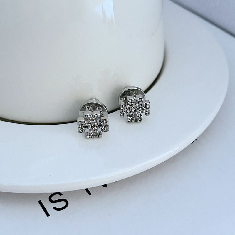 Extreme close-up of one stud, focusing on the engraved or embossed Double T logo and edges.