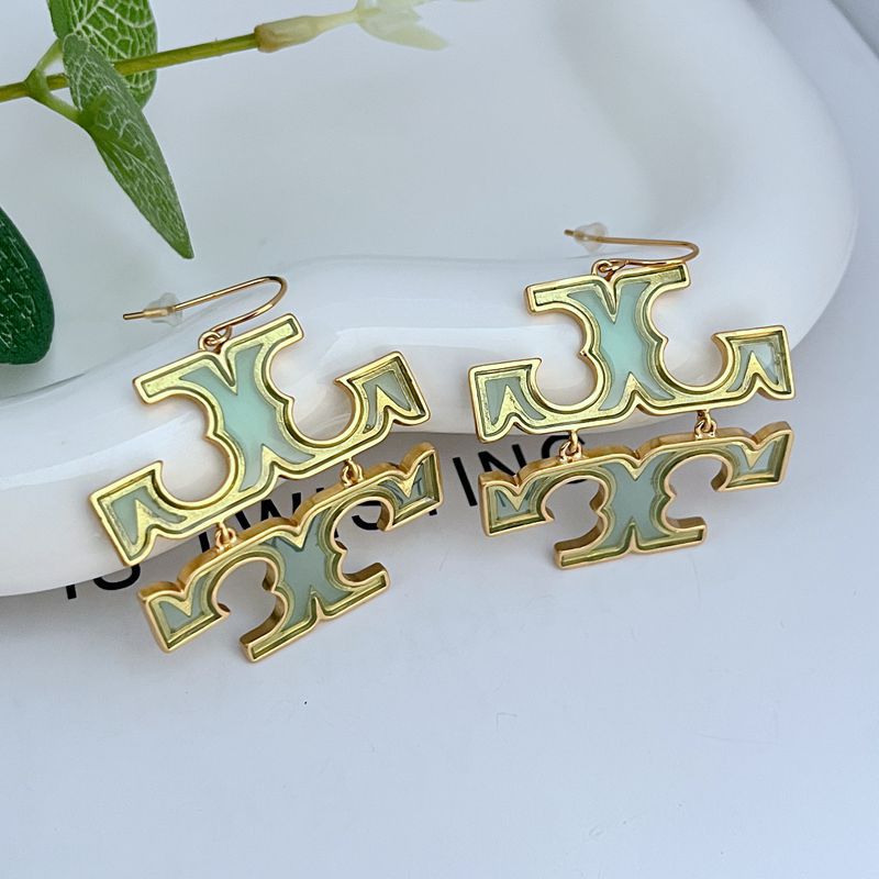 The earrings laid flat on a blueprint, a modern art book, or a marble surface with clean lines, reinforcing the theme of structured, design-forward aesthetics.