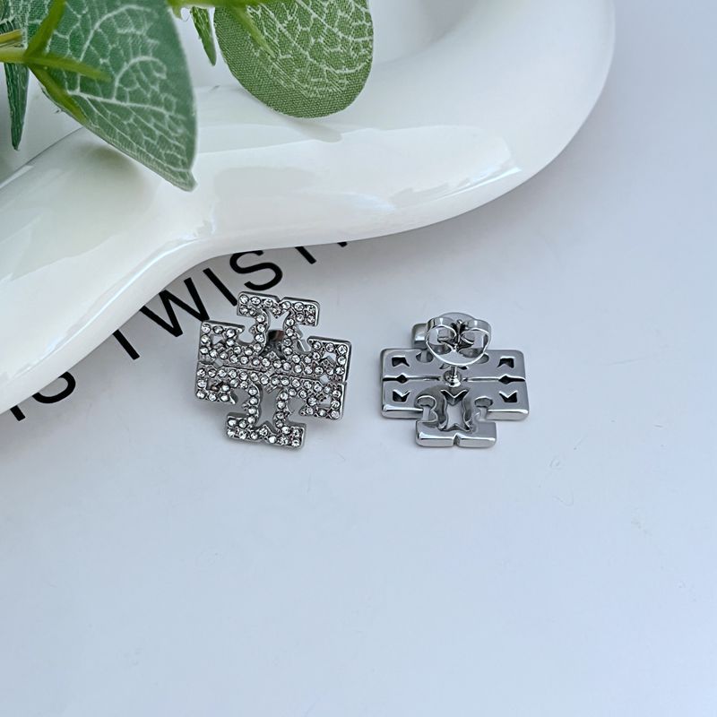 Studs worn on a model, capturing how they catch light and add a refined, glittering accent to the earlobe.