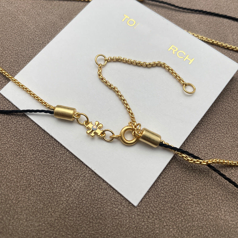 Close-up focused on the pearl nestled within the chevron, showcasing the pearl's luster and the metal's polished edges.