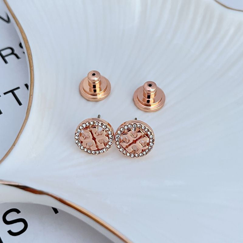 Studs worn on a model, capturing how they catch light and add a refined, luminous accent to the earlobe.