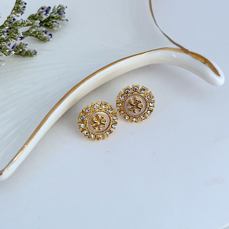 Both studs displayed face-up on a dark blue or midnight-inspired background, making the celestial shapes and crystals stand out.