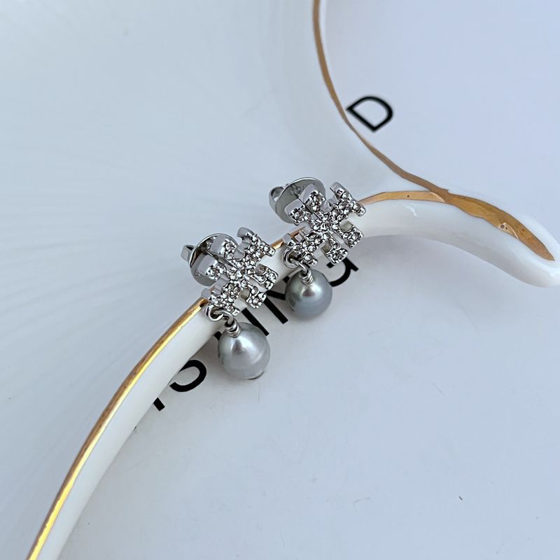 Earrings worn on a model, capturing the graceful dangle and how they catch light with movement.