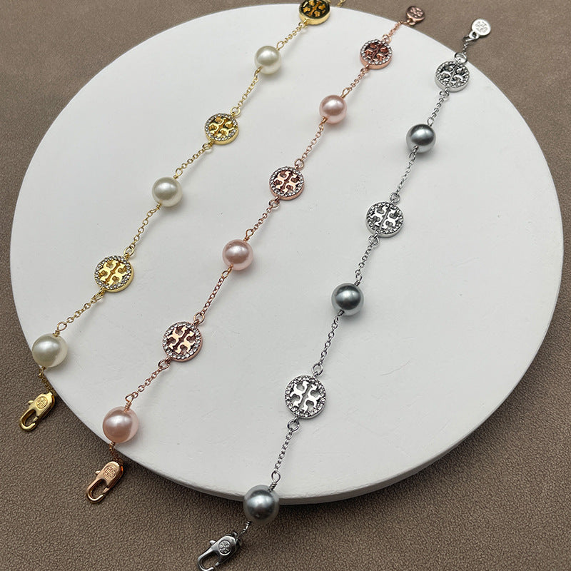 Necklace laid flat on a muted, textured background (e.g., gray slate or linen), highlighting the contrast between the organic pearl and the sparkling pave details.