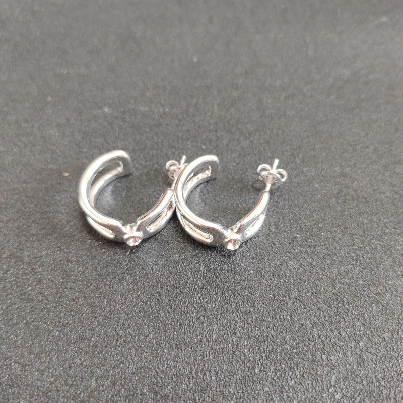 Hoop earrings on neutral or gemstone-inspired background. Alt: “UNOde50 Hoop Earrings with White Topaz – Silver Crystal Hoops.”