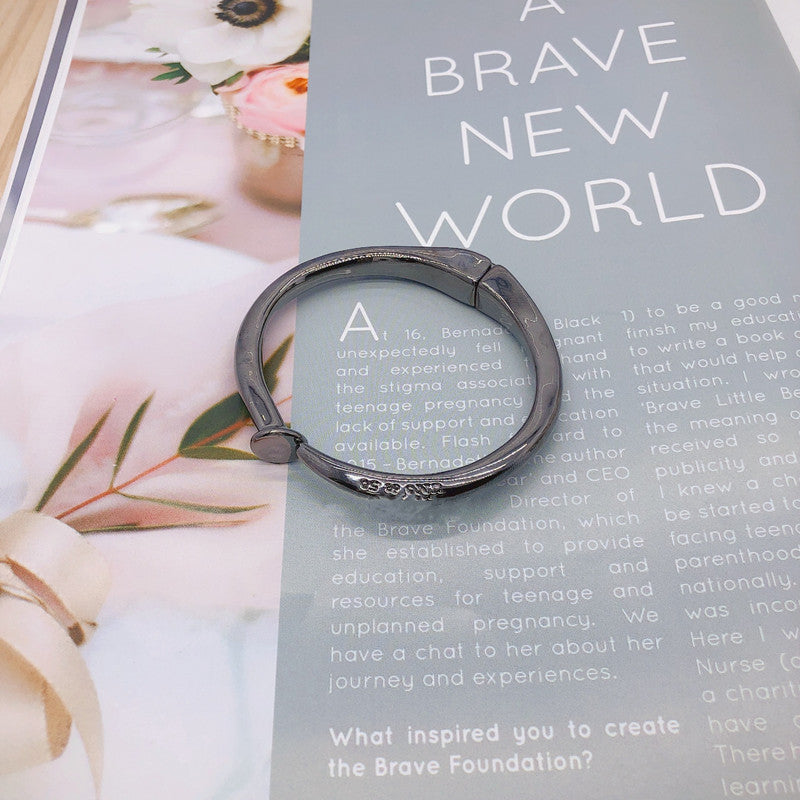 Nail-shaped bangle on neutral or edgy background. Alt: “UNOde50 Nail-Shaped Bangle Bracelet – Silver Sculptural Bangle.”