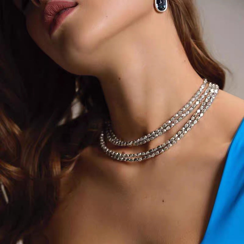 Necklace worn as meaningful statement. Alt: “Journey's Path: UNOde50 Paths Necklace.”