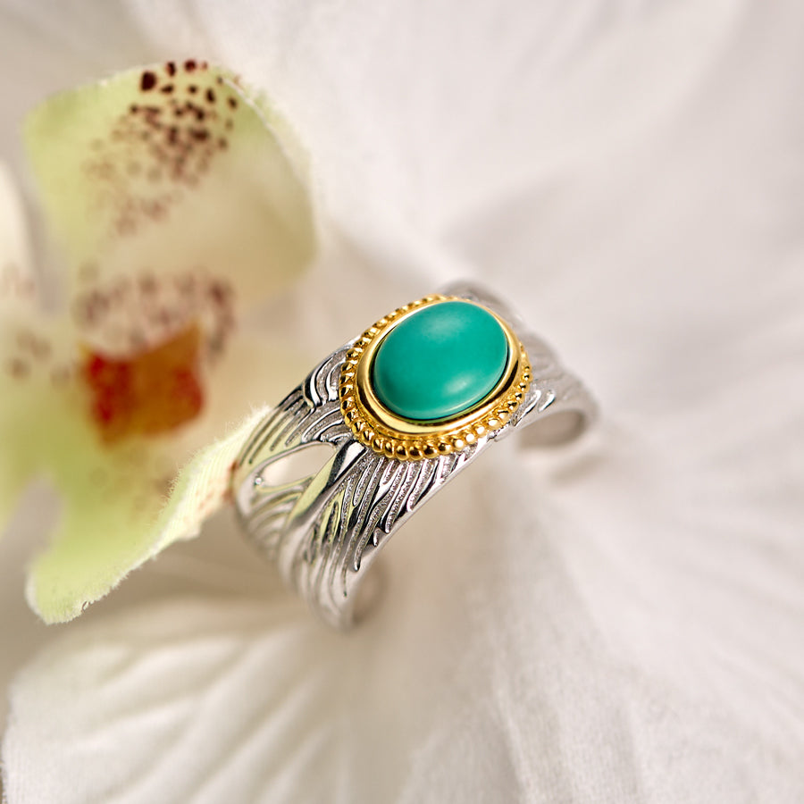 Silver ring with a turquoise stone on a white flower background