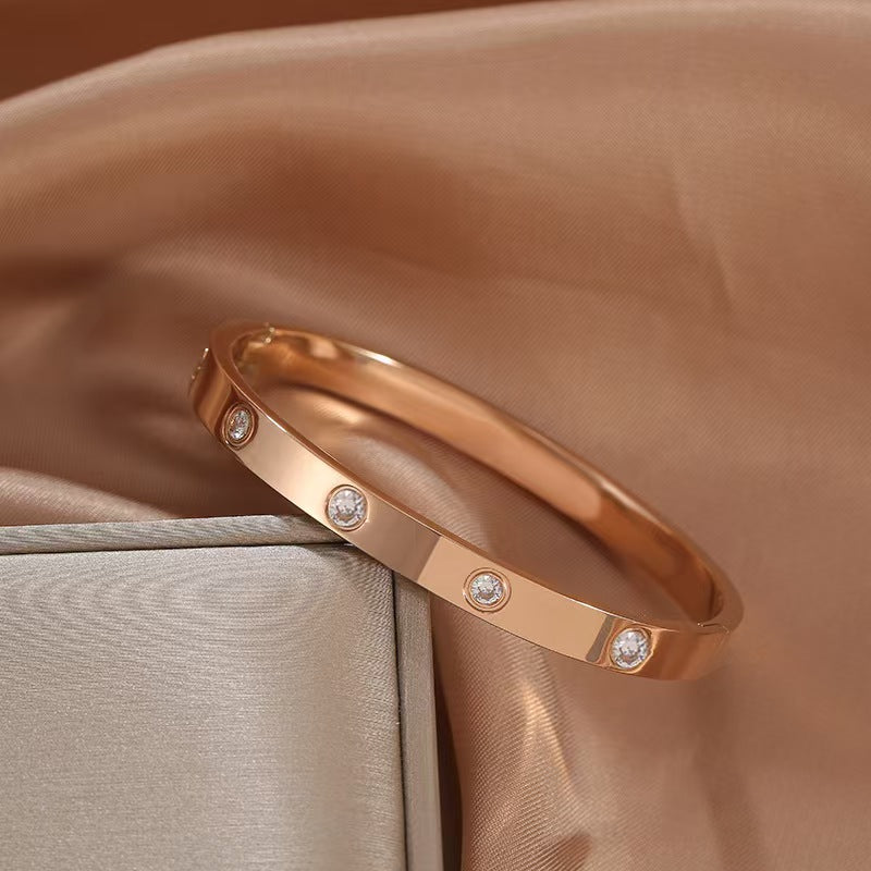Rose gold bracelet with diamonds on a soft fabric background