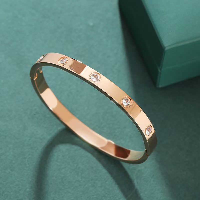Rose gold bracelet with diamonds on a teal background