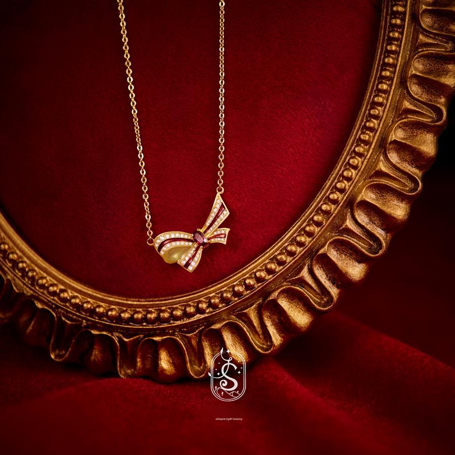 Gold necklace with a butterfly pendant on a red background