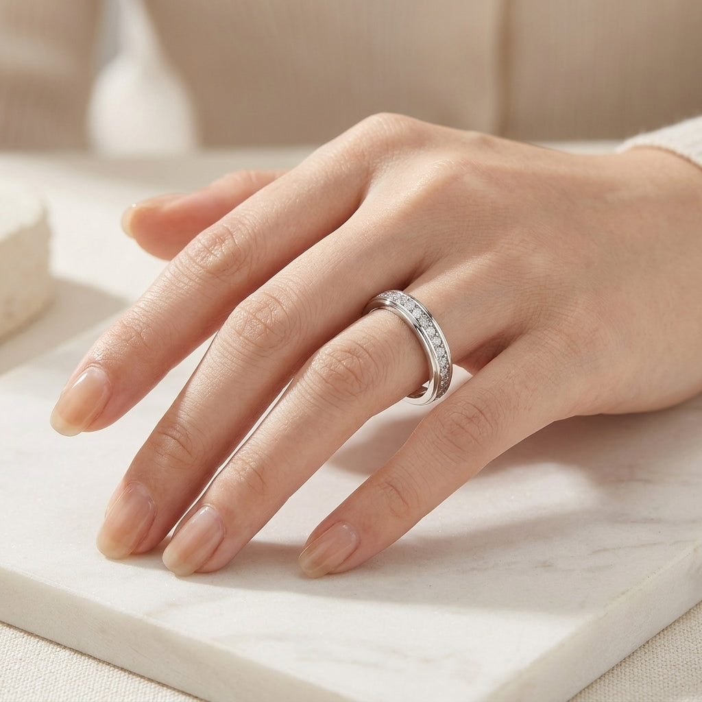 Close-up view of model showing smooth channel set moissanite eternity band on hand.