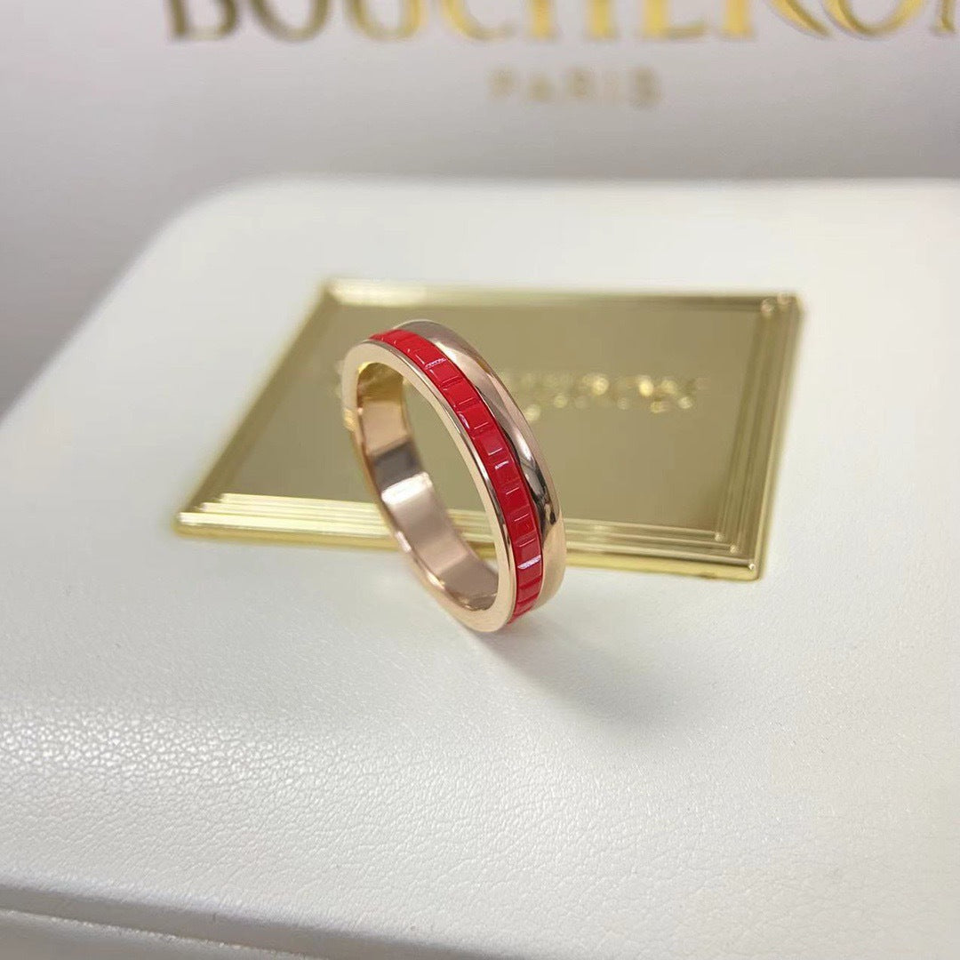 Luxury lifestyle shot of a bold crimson red HyCeram ceramic Paris grooves band ring in a premium rose gold plated finish.
