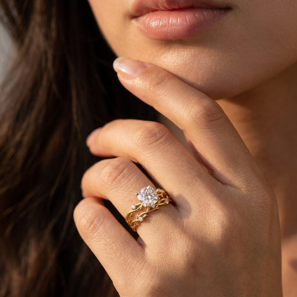 Model showing cushion cut moissanite botanical twig ring set on hand near face.