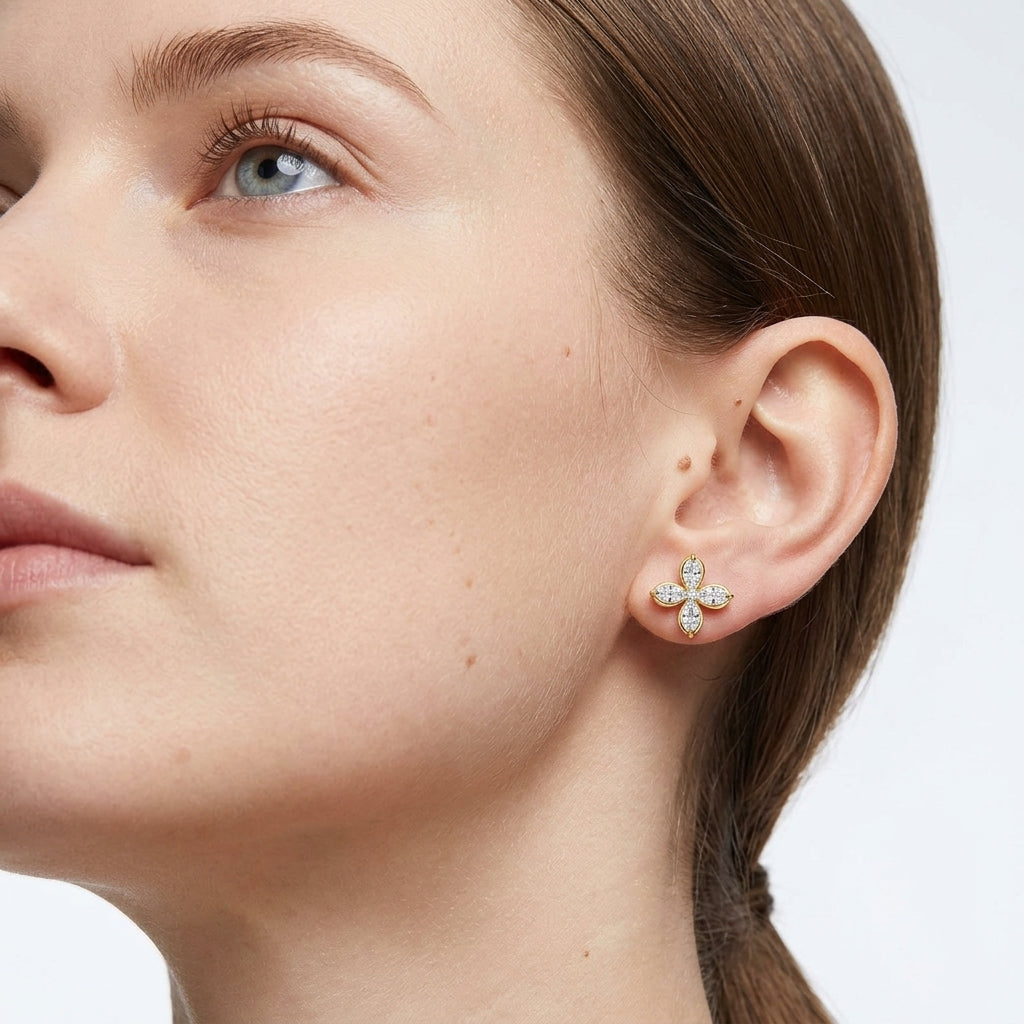 Model wearing gold marquise cut moissanite four-leaf clover studs in a daylight portrait.