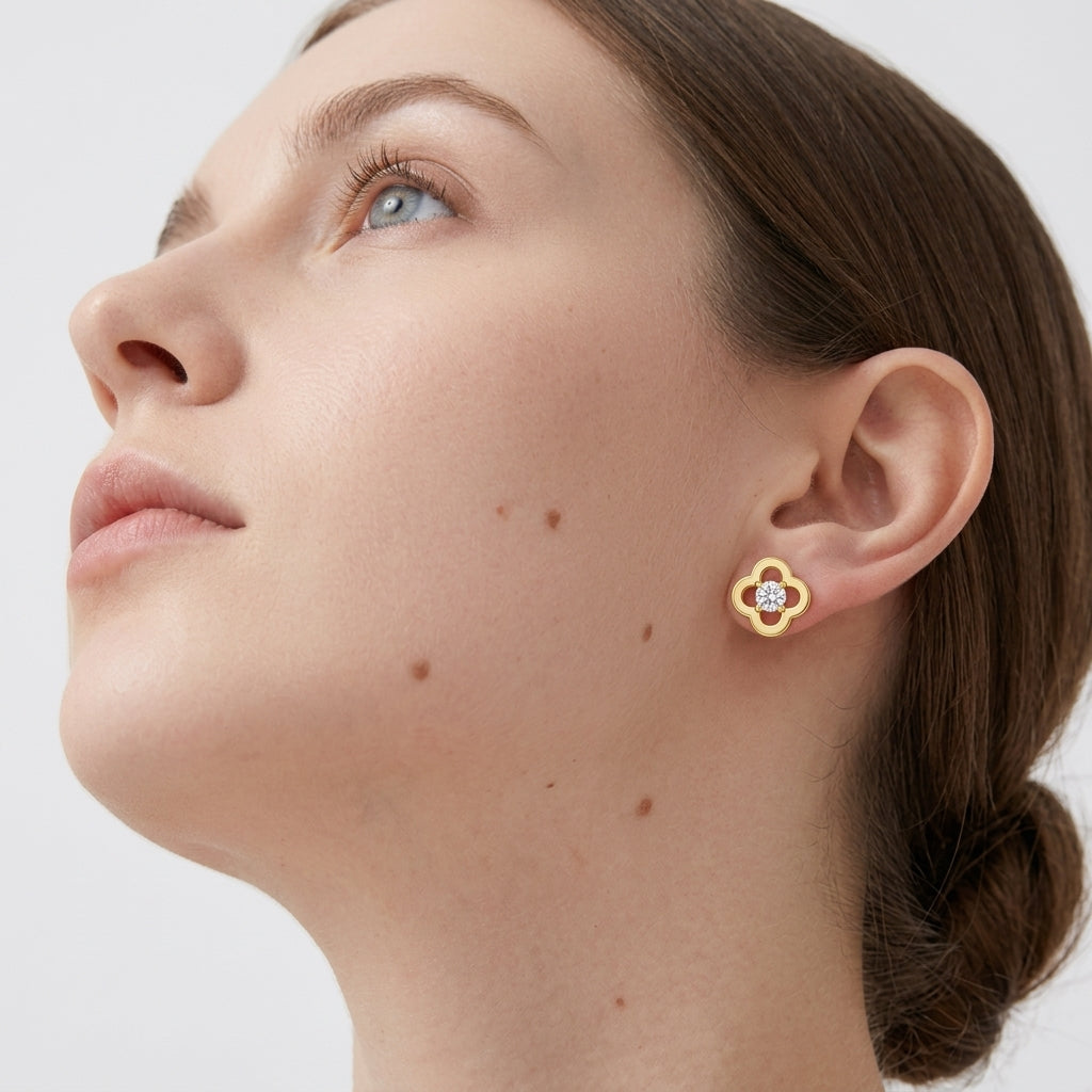 Model wearing gold round cut moissanite four-leaf clover stud earrings in a daylight studio shot.