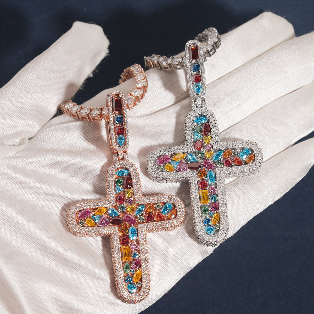 Hand in white glove holding S925 silver iced out multi-color moissanite rounded cross pendants