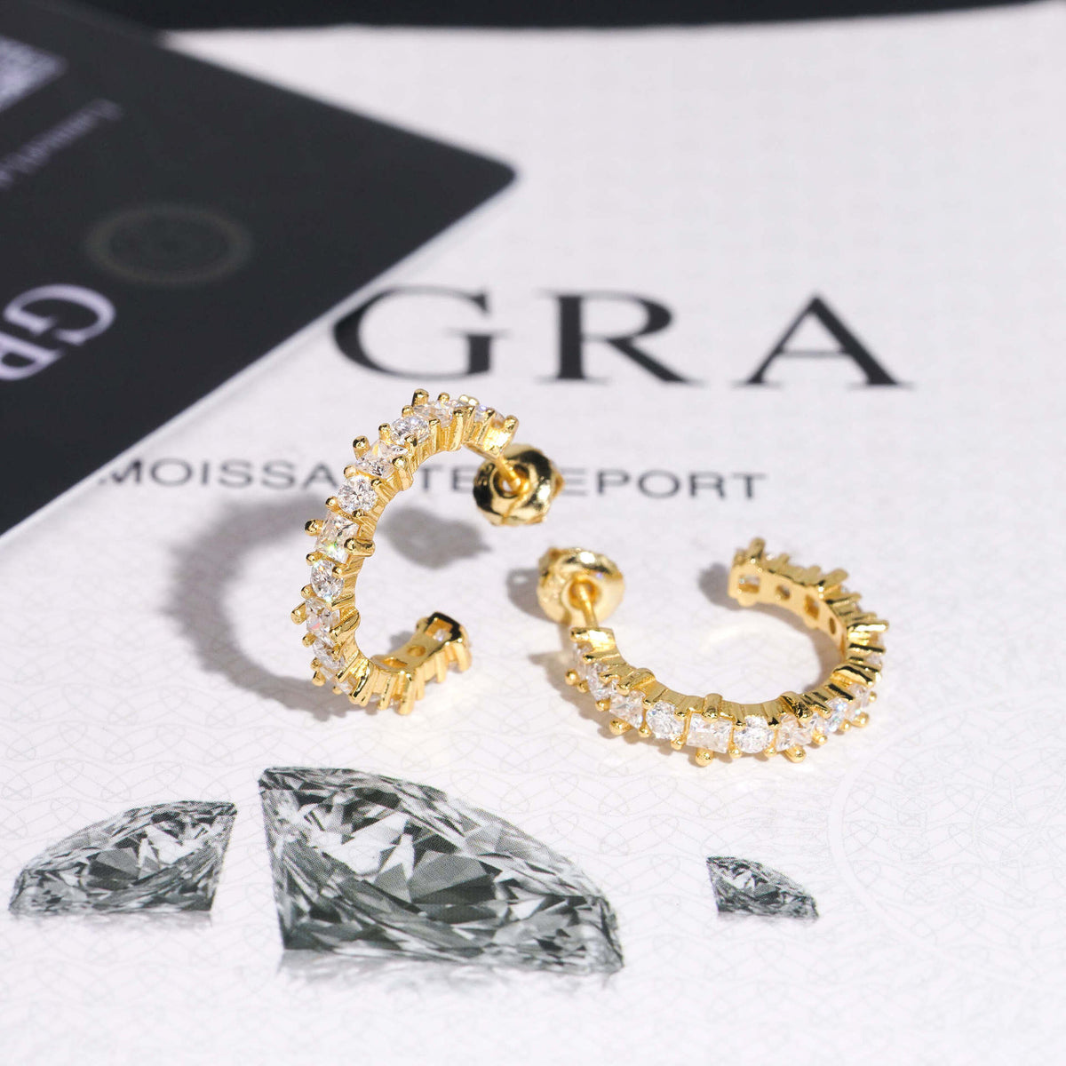 Yellow gold iced out eternity C-shaped half hoop moissanite stud earrings showing screw backs on GRA report card
