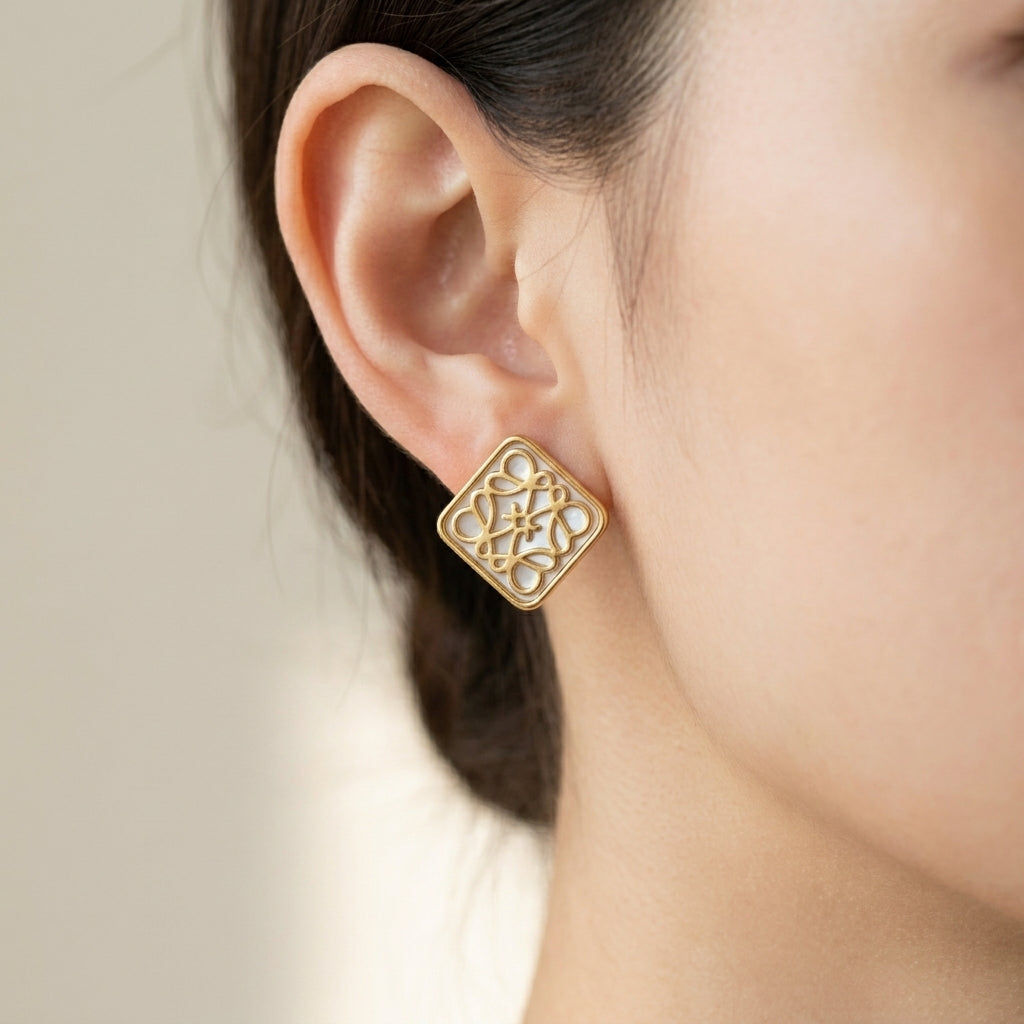 Model touches hair wearing Loewe Openwork Studs, capturing the play of light through the logo