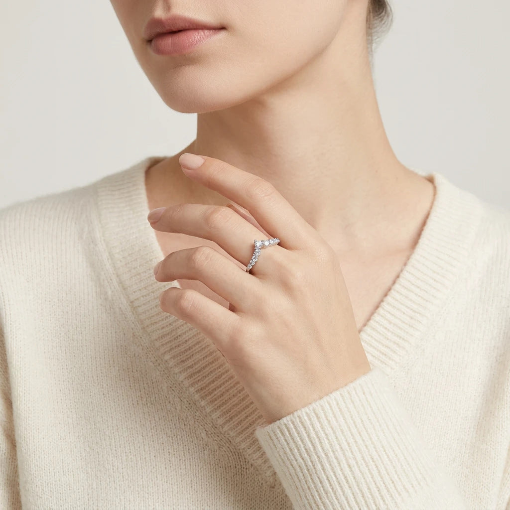Fashion editorial wear shot of a model styling a timeless romantic v contour moissanite anniversary jewelry piece with a sweater.