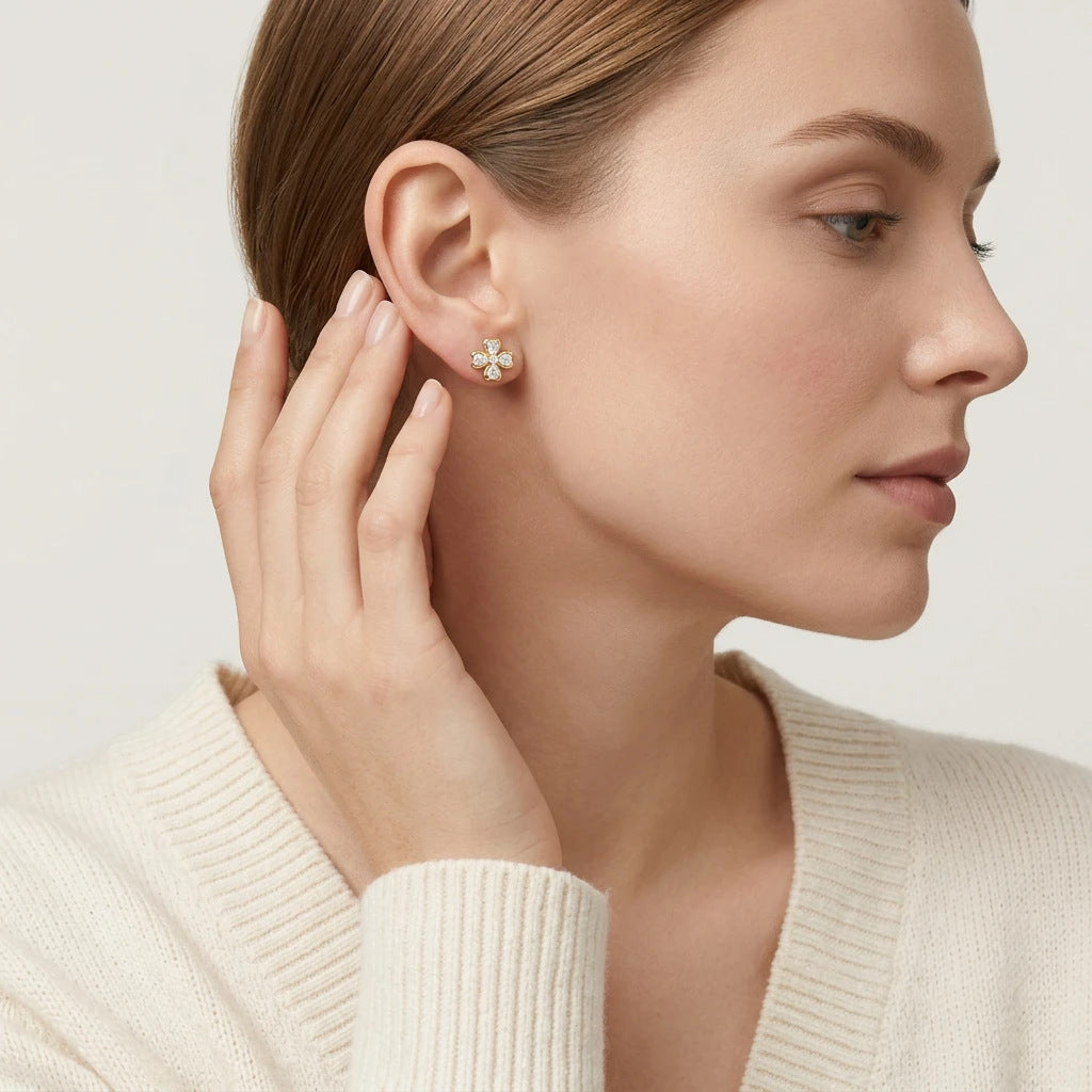 Editorial fashion lookbook portrait of a model styling timeless romantic vca inspired moissanite clover studs with a white top.
