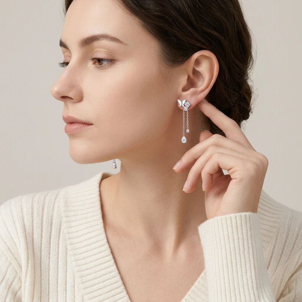 Editorial fashion lookbook portrait of a model styling timeless romantic vintage butterfly moissanite evening drop earrings.