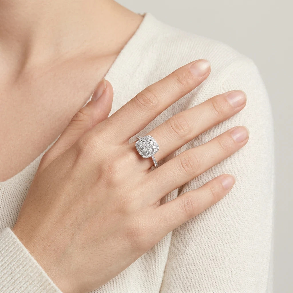 Lifestyle fashion lookbook portrait of a model styling a sugar cube halo cluster moissanite ring across her chest.