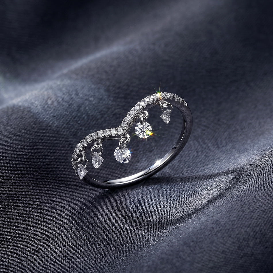 Perspective view of 0.49ct V-shaped wishbone lab diamond dangling charm ring on dark silk.