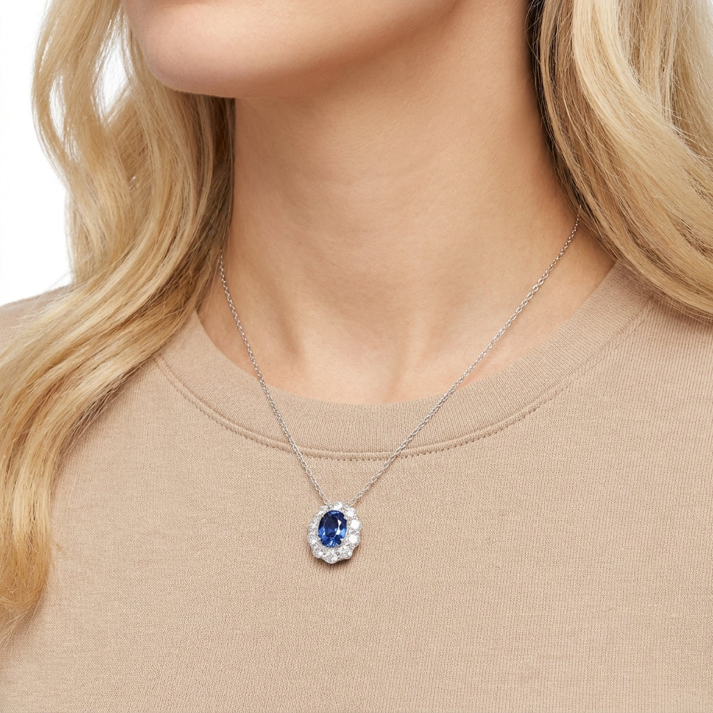 Elegant model wearing a 0.8ct oval blue sapphire pendant necklace with halo design.