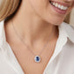 Lifestyle close-up of a model wearing a 0.8ct oval sapphire halo pendant necklace.