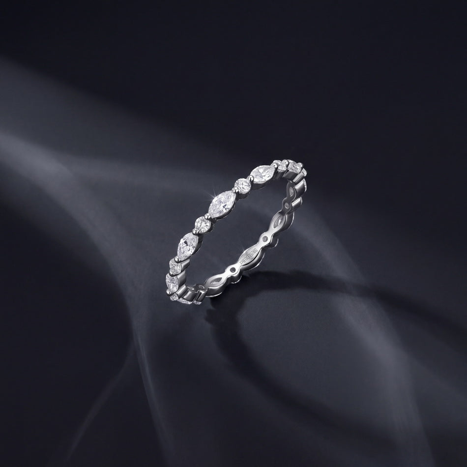 Side angle view of 0.9ct marquise and round lab diamond eternity band resting on soft fabric.