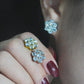 Earrings worn as romantic statement. Alt: “Floral Sparkle: Moissanite Cluster Earrings.”