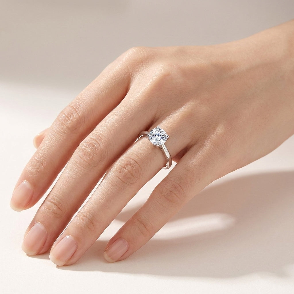 Top-down view of classic 1.07ct round lab diamond solitaire ring worn on finger.