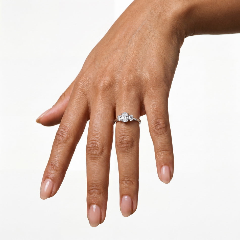 Close-up shot of model hand wearing 1.17ct oval cut lab diamond three stone anniversary ring.