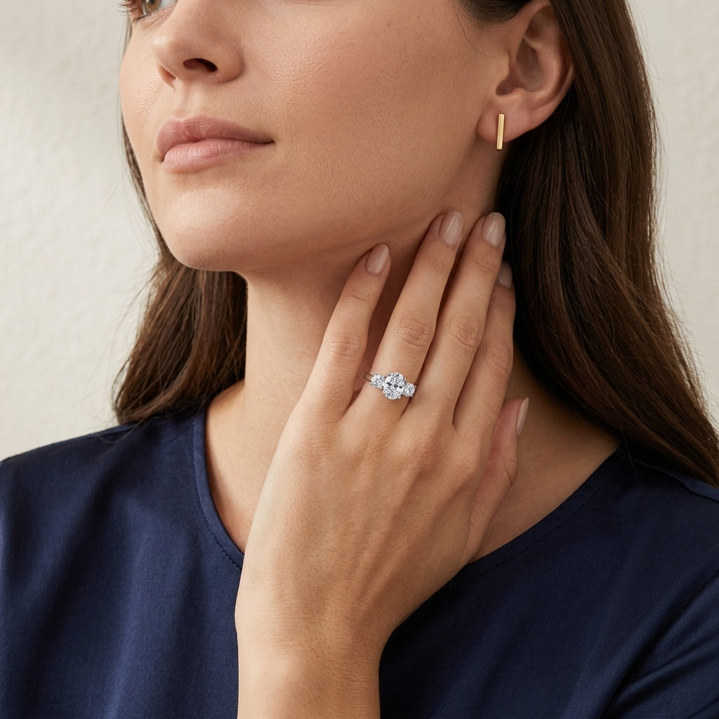 Model wearing 1.17ct oval cut lab diamond three stone engagement ring on ring finger.