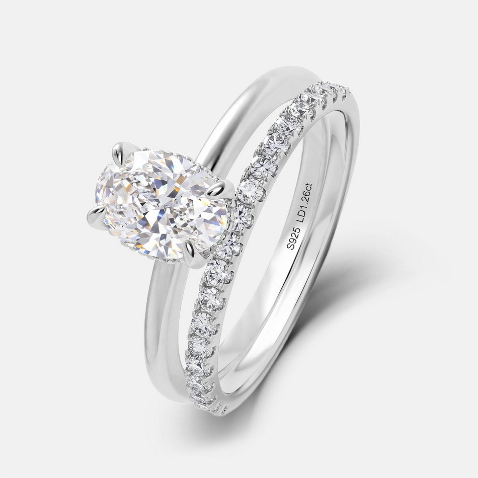 Angled profile view of 1.26ct oval cut lab diamond solitaire ring stacked with pavé matching band.