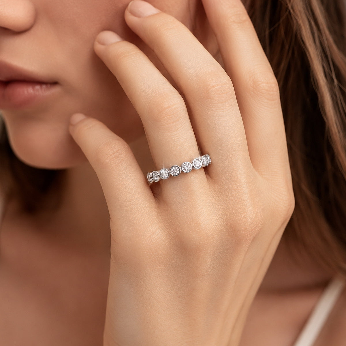 Model wearing 1.31 ctw bezel set round cut lab grown diamond eternity ring on finger