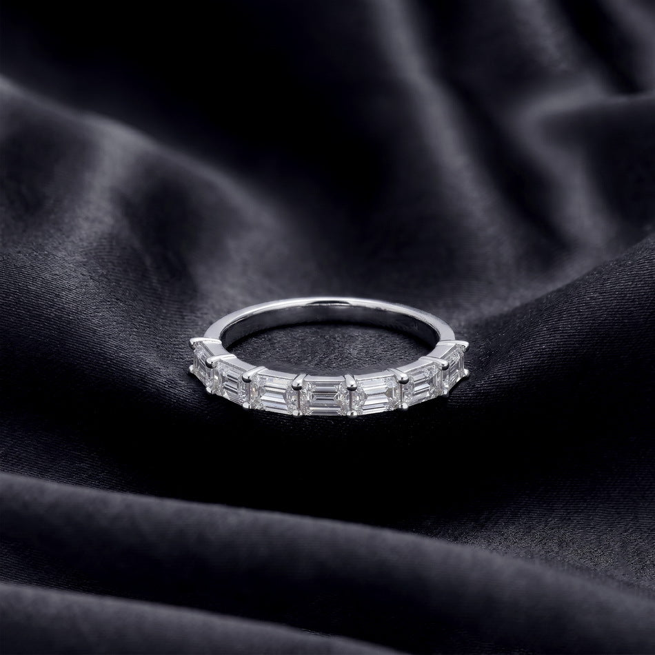 Perspective shot of 1.45ct emerald cut lab diamond half eternity band on black silk background.