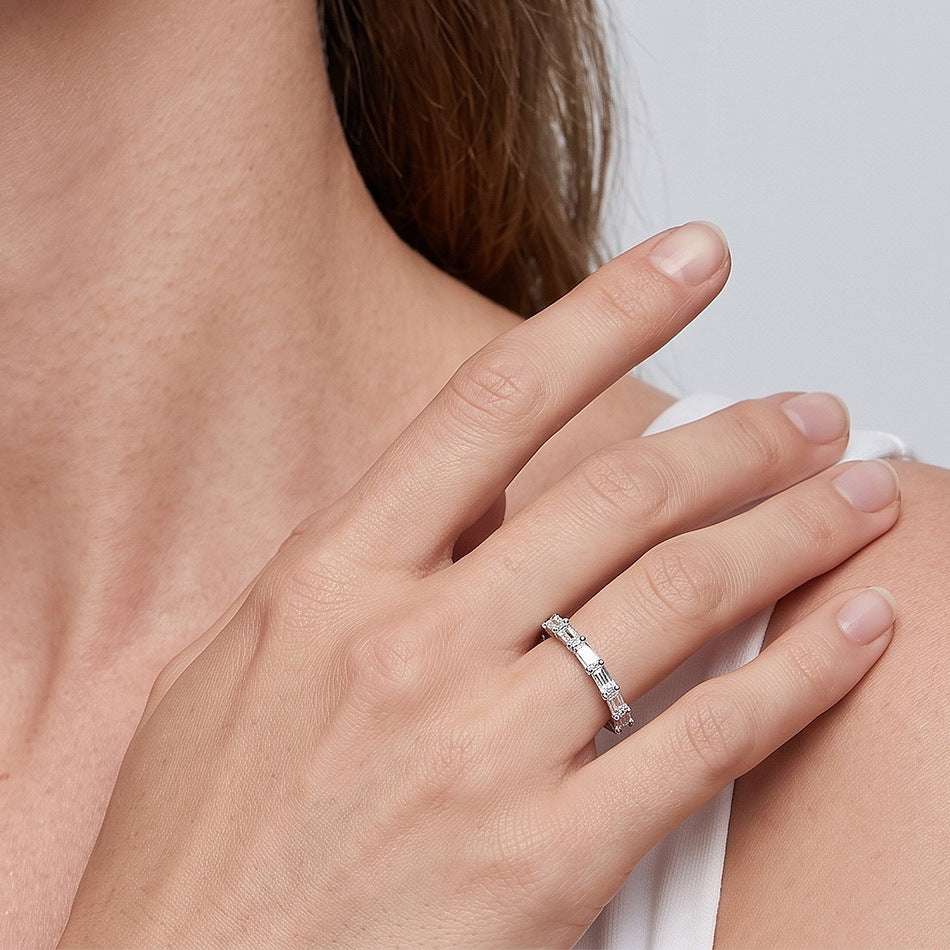 Model wearing 1.45ct emerald cut lab diamond half eternity band ring on ring finger.