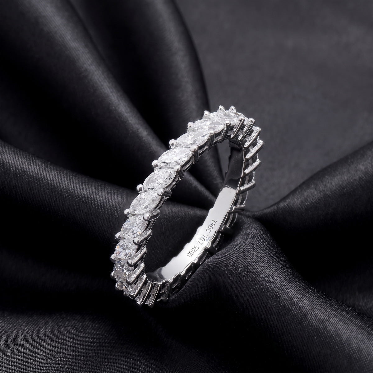 Angled view showing claw setting of 1.56 ctw marquise cut lab grown diamond eternity ring on dark black silk