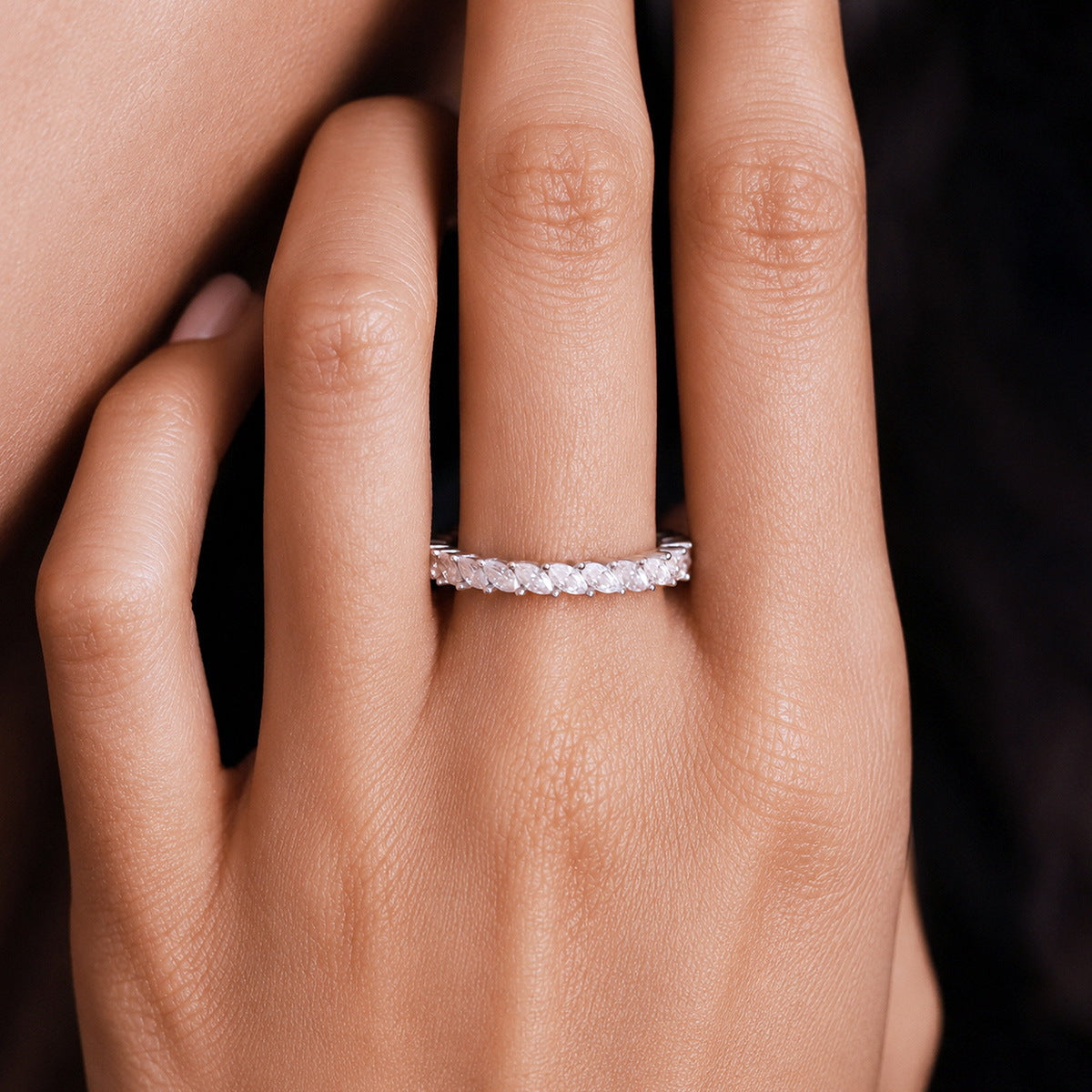 Close up view of woman wearing 1.56 ctw marquise cut lab grown diamond eternity ring on hand
