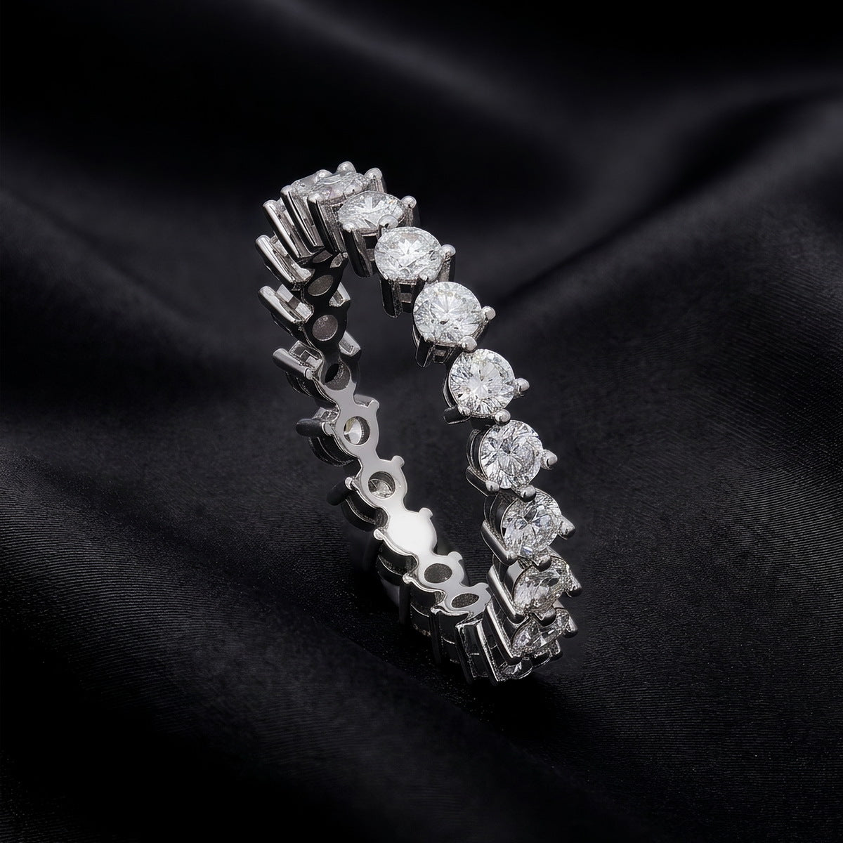Side profile view showing shared prong setting of 1.90 ctw lab grown diamond eternity ring on black silk