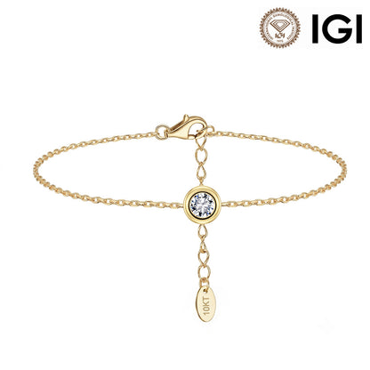 A gold chain bracelet with a small round bezel-set clear gemstone and a dangling oval tag engraved with 'IGI', shown on a white background with an IGI logo in the top right corner.