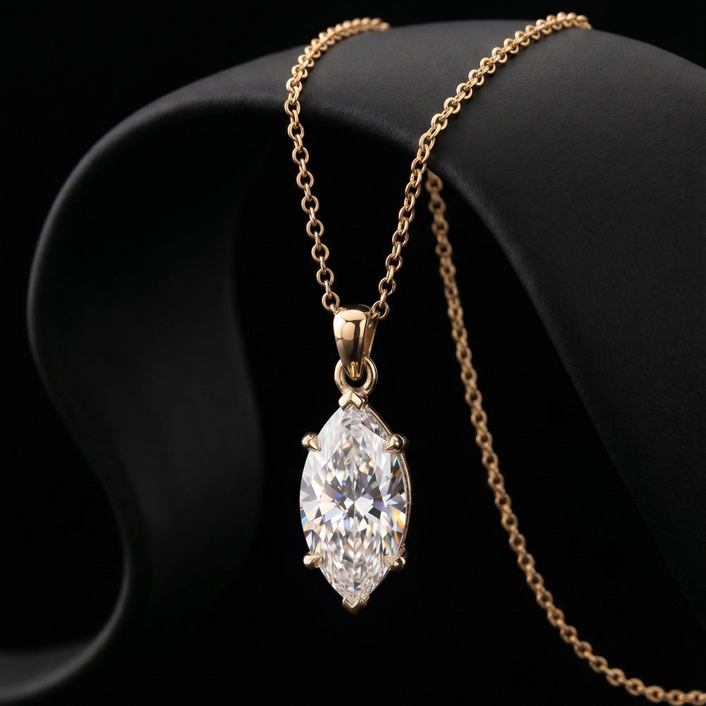 A gold pendant necklace with a marquise-cut clear gemstone, displayed on a black curved jewelry bust against a black background.