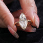 Close-up of hand holding 10k yellow gold marquise lab diamond solitaire V ring showing brilliant sparkle