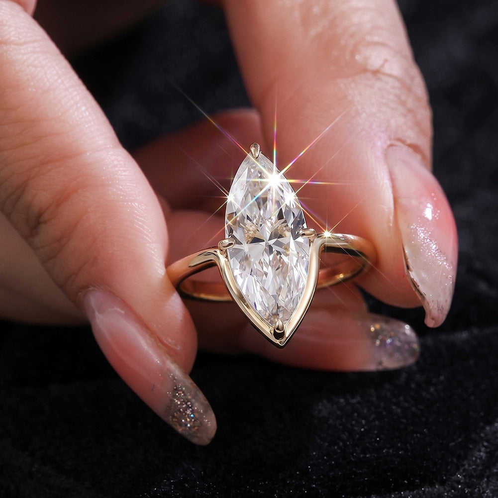 Close-up of hand holding 10k yellow gold marquise lab diamond solitaire V ring showing brilliant sparkle
