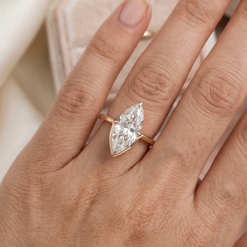 Close-up of model wearing 10k yellow gold marquise cut lab diamond V solitaire engagement ring